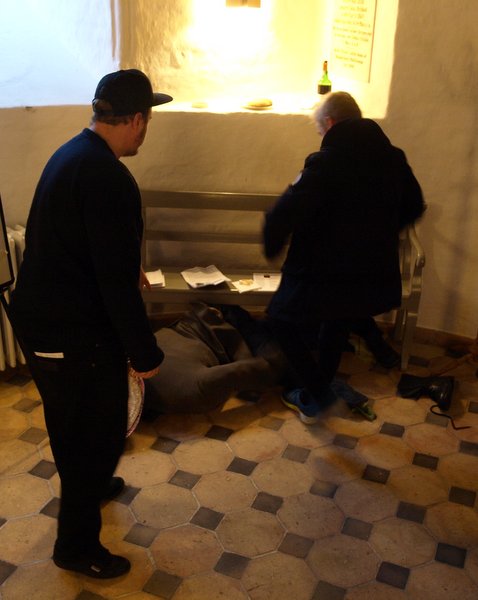 En af drengene går løs på den sovende mand, mens rollespilleren til venstre ser til